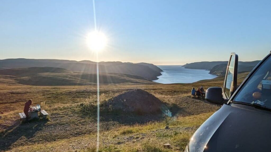Black VW California at a viewpoint above a Norwegian fjord at sunset